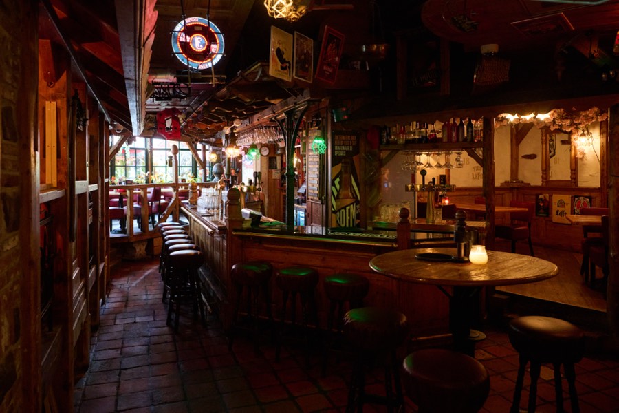 Het dorpsplein en de lounge van The Old Pal met de bar en barkrukken